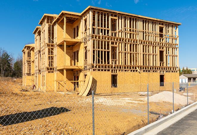 a close-up of temporary chain link fences enclosing a construction site, signaling progress in the project's development in Montrose